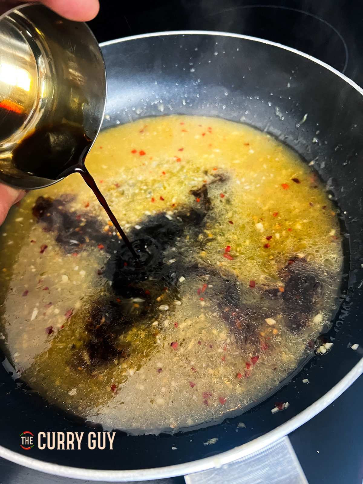 adding soy sauce to the wok.