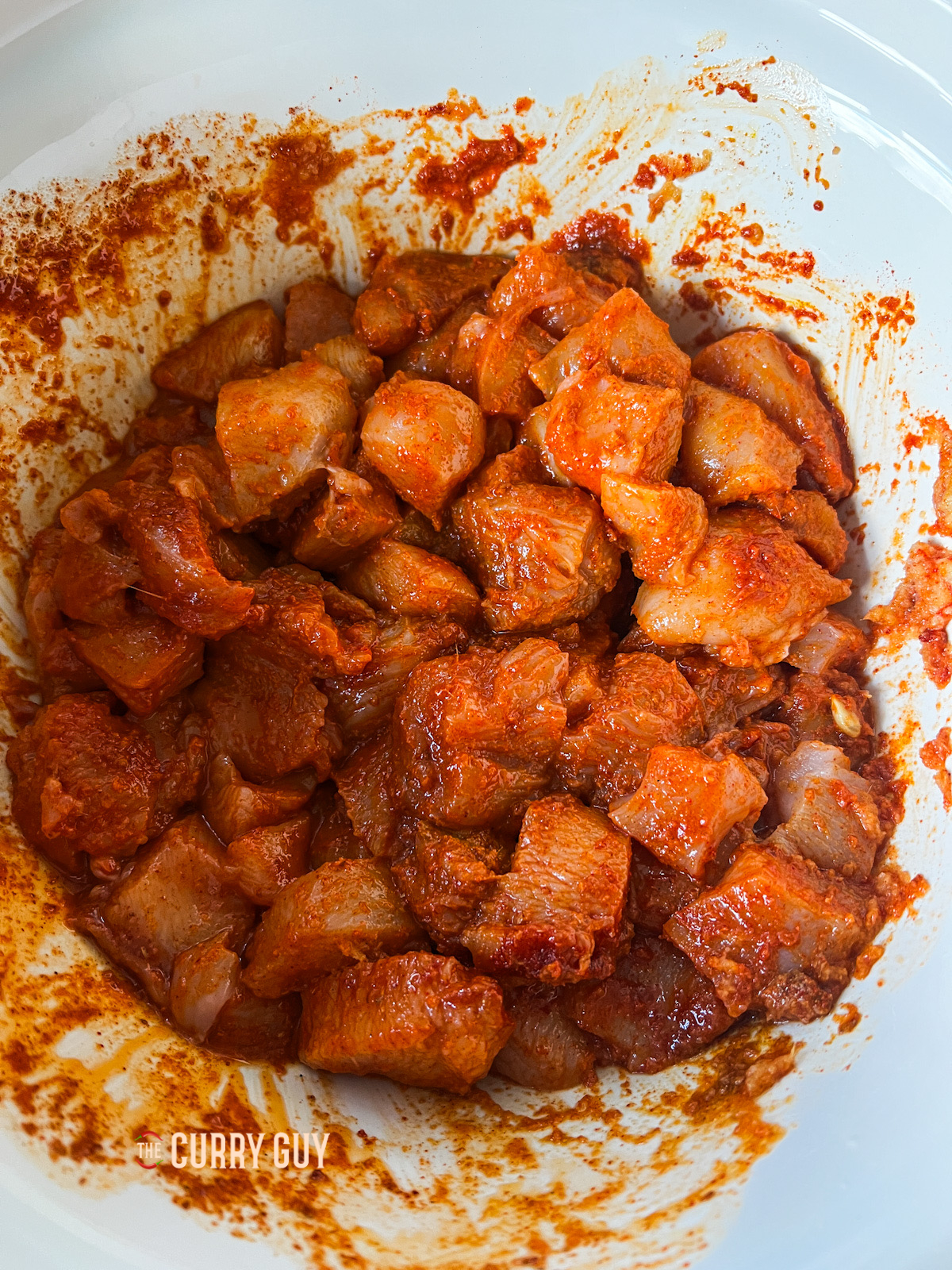 Slow cooker butter chicken marinating chicken.