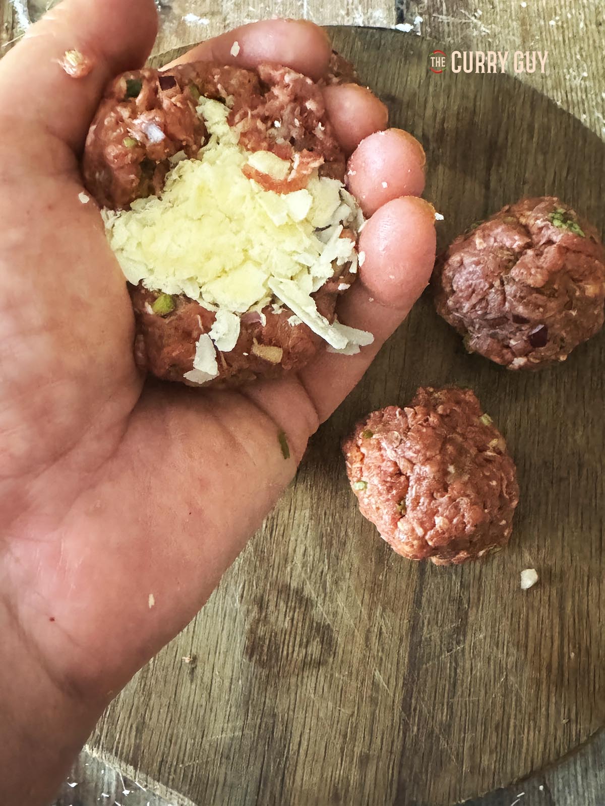 Stuffing the meatballs with cheese.