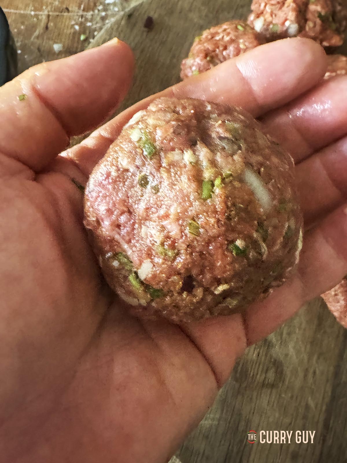 Rolling the cheese stuffed meatballs into smooth koftas.