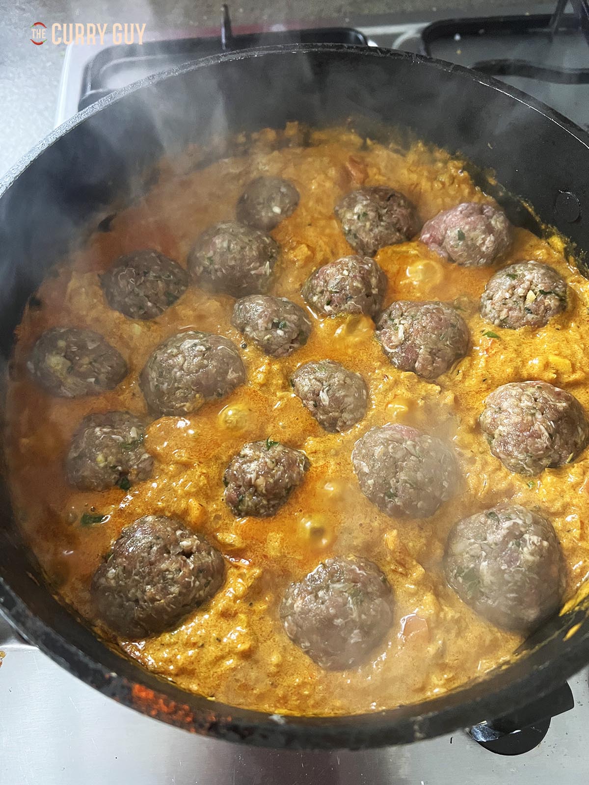 Adding the kofta to the sauce.