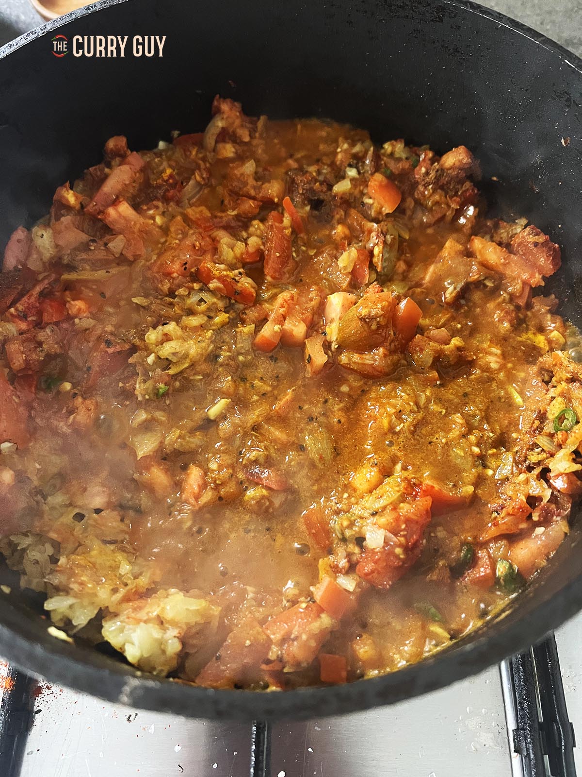 Adding the stock to the pan and simmering for 3 minutes.