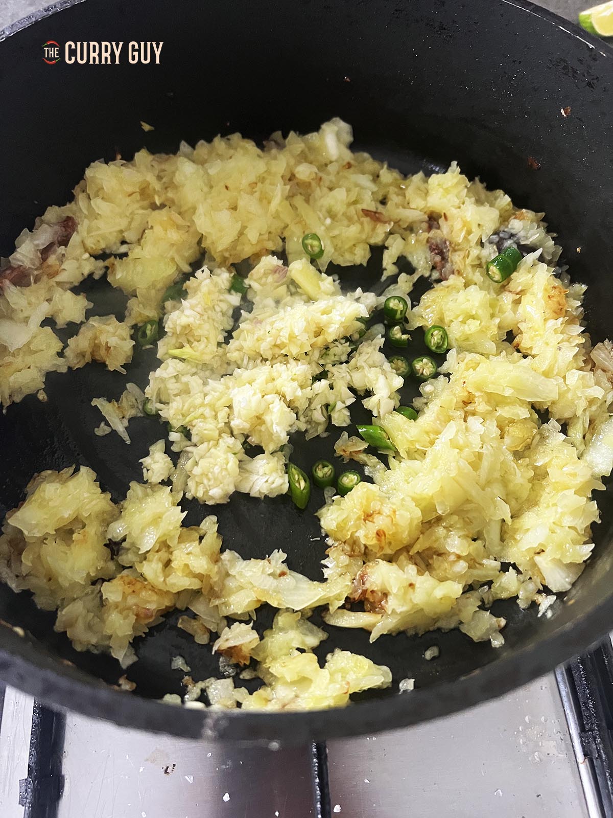 Adding garlic and ginger paste to the onions in the pan.