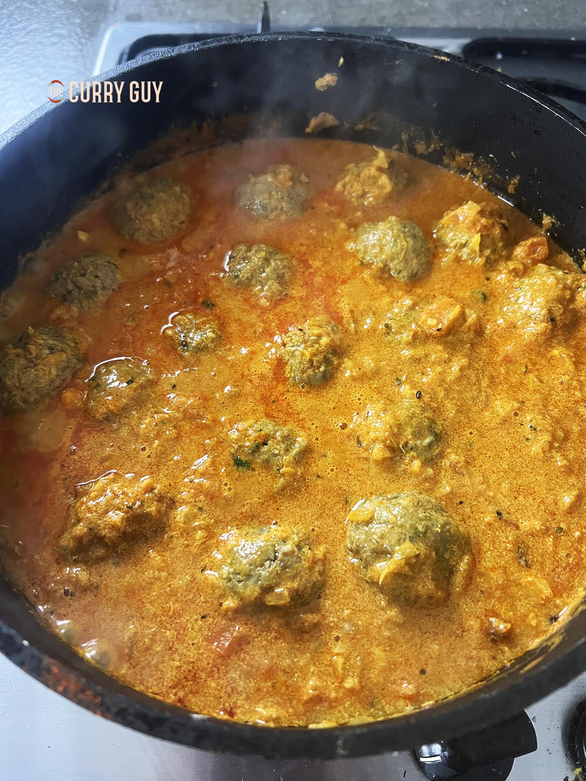 Simmering the koftas.