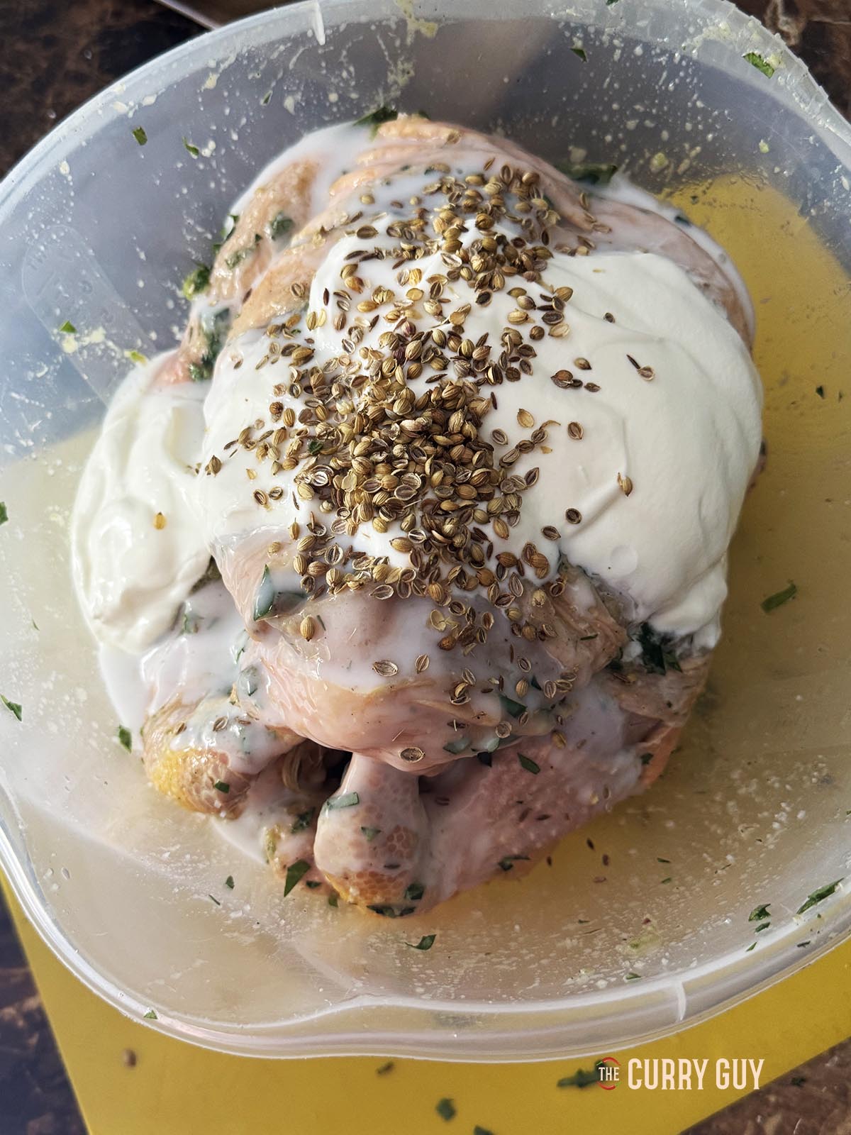 Adding the yoghurt, coconut milk, ground cumin and coriander to the bowl.