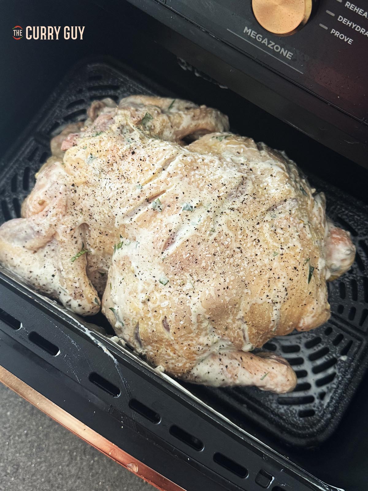 The chicken, breast side down in the air fryer basket.