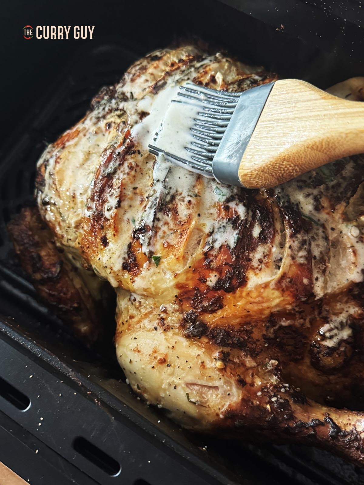 Basting the chicken after 10 minutes of cooking.