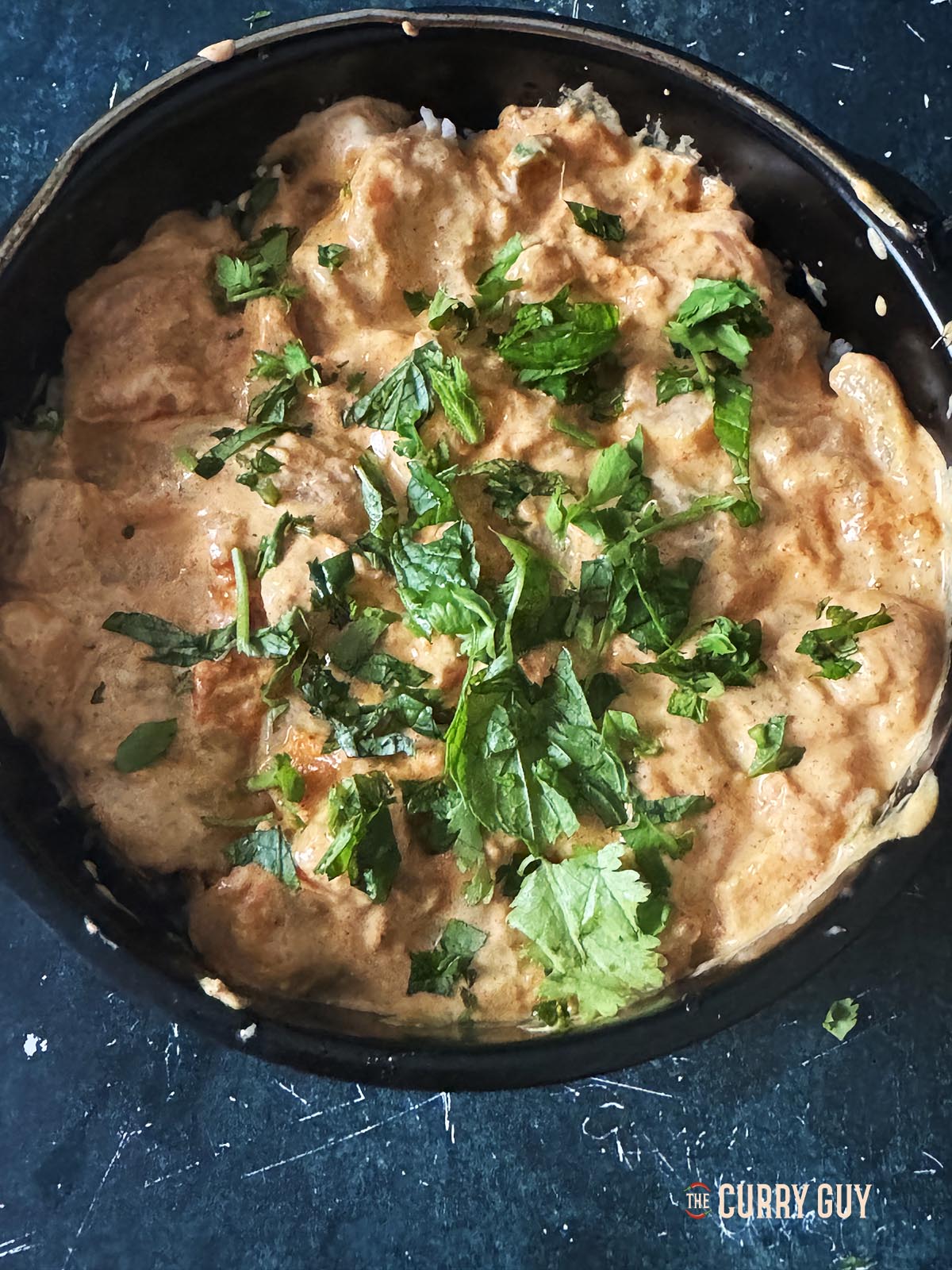 Adding the chicken to the biryani. Layering it on top of the first two layers.
