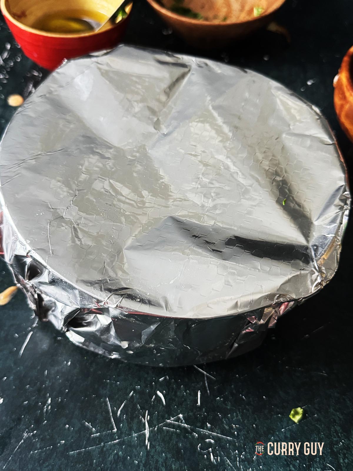 Covering the pan tightly with foil to begin cooking.