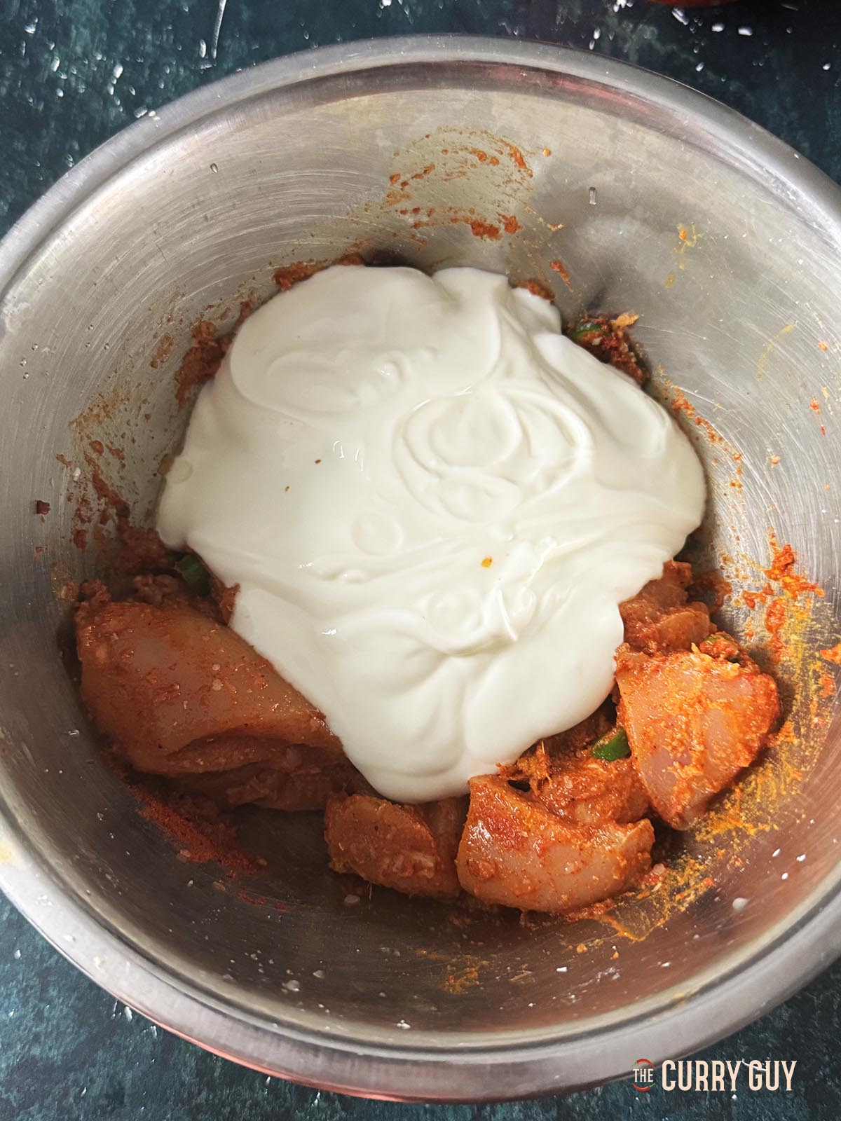 Topping the chicken with the yoghurt.