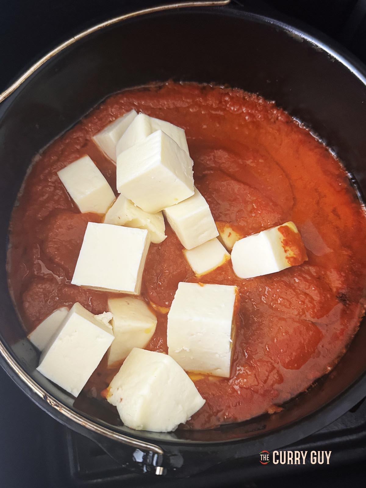 Adding the paneer to the sauce. 