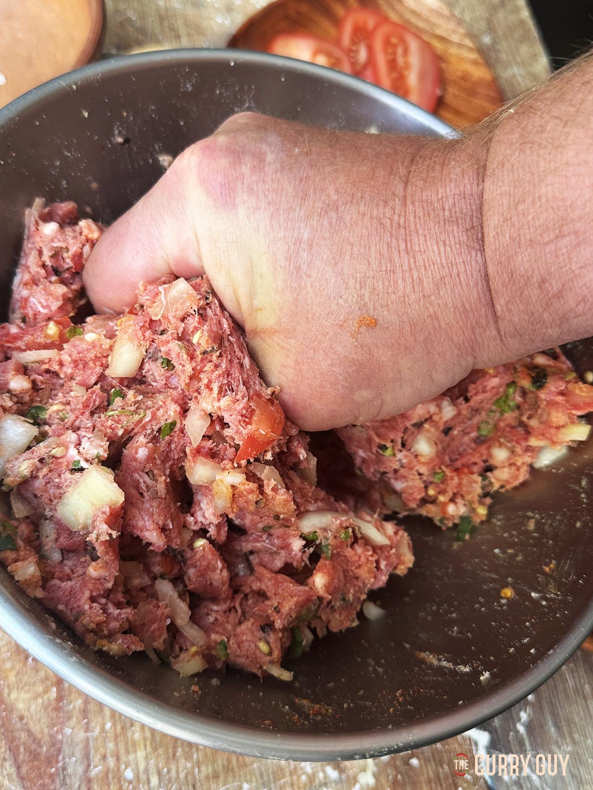 Kneading the meat and other ingredients for the kebabs.