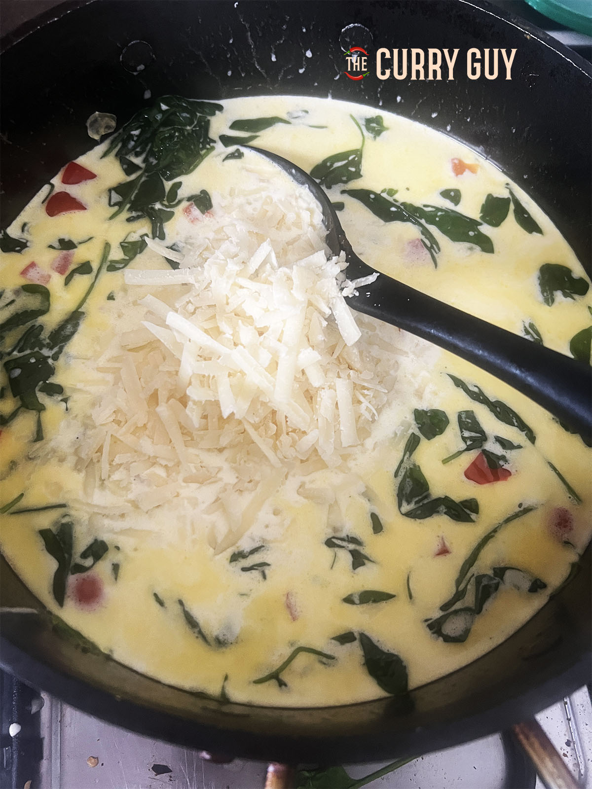 The parmasan being added to the simmering sauce.