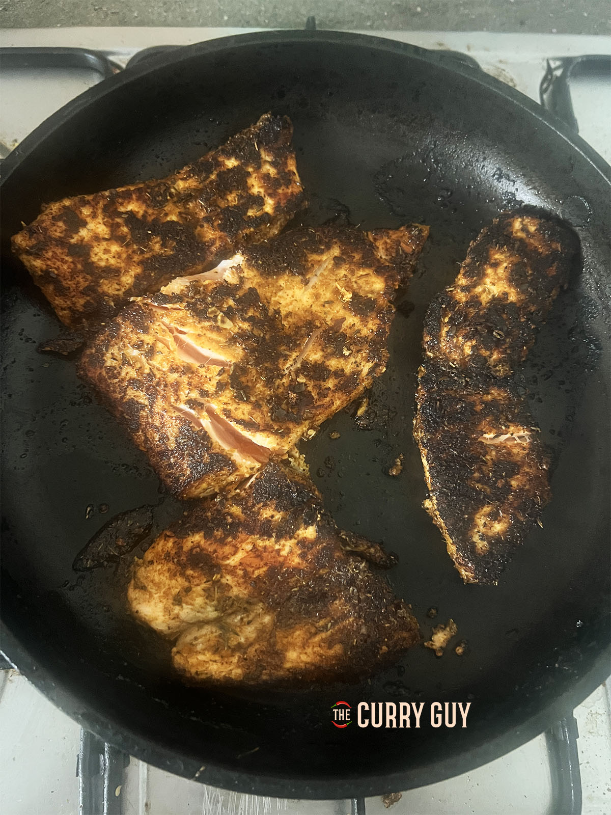 Salmon steaks frying in the Cajun rub.
