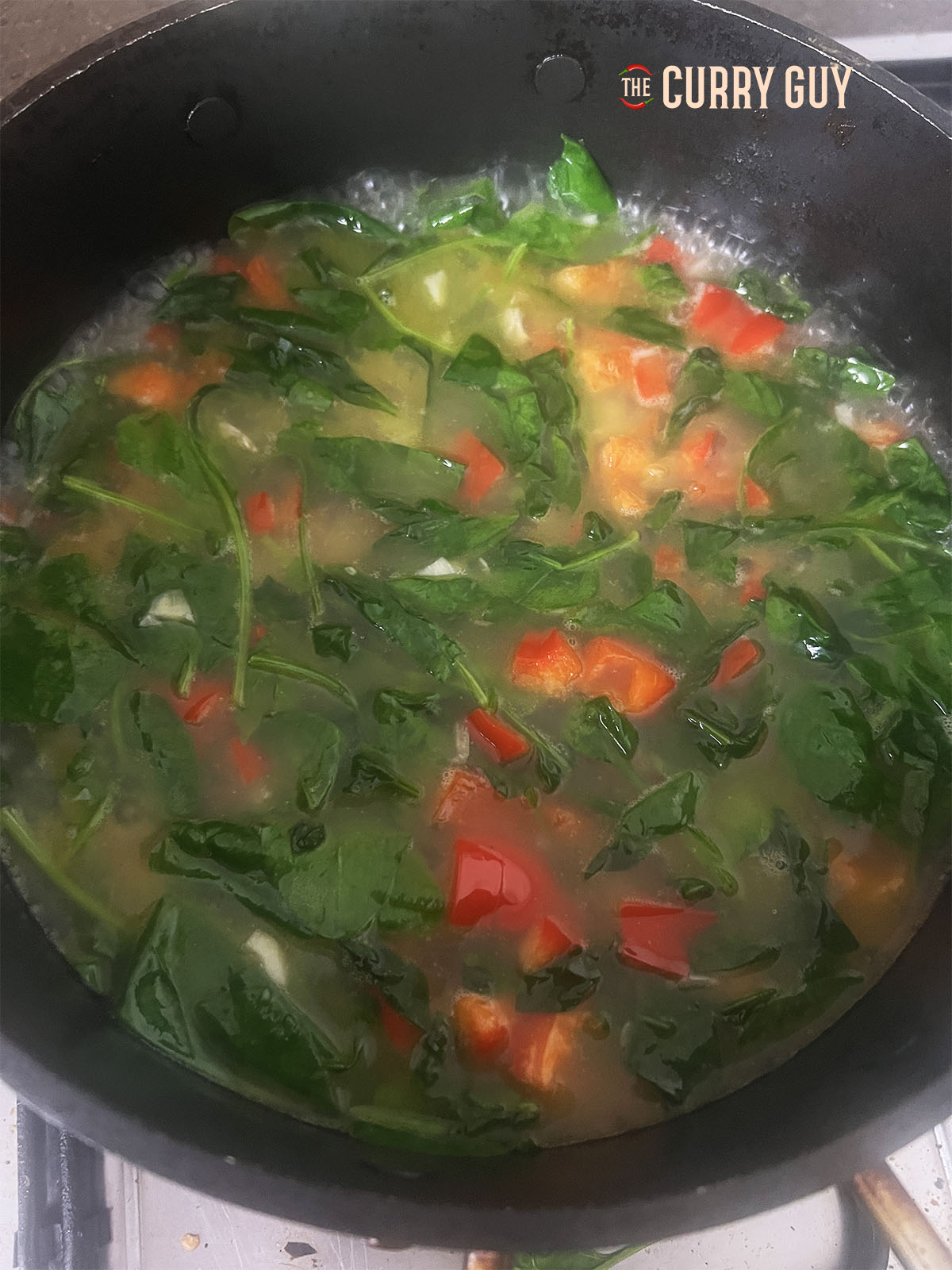 Pan showing chicken stock beomg added.