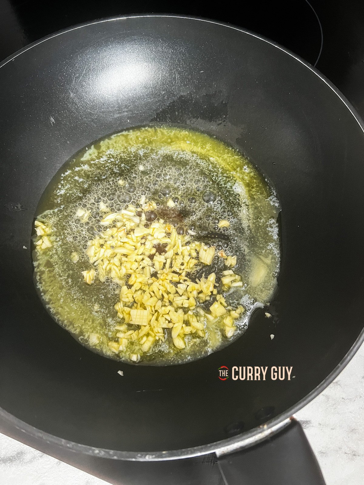 Melting the butter and frying the garlic in a pan.