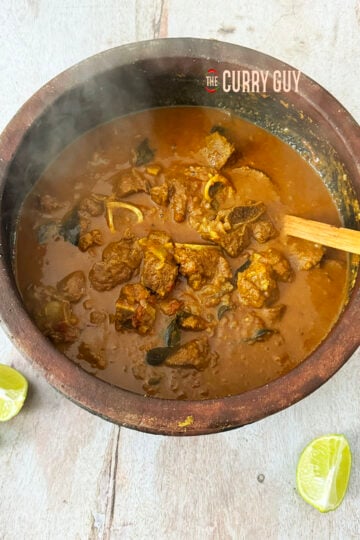 The finished Keralan lamb curry in a pot at the table.