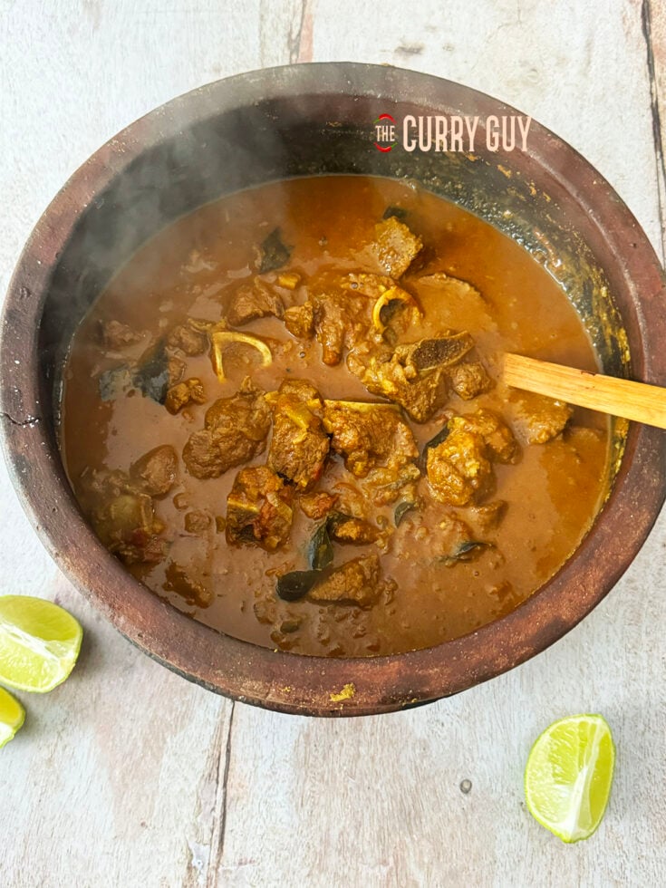 The finished Keralan lamb curry in a pot at the table.