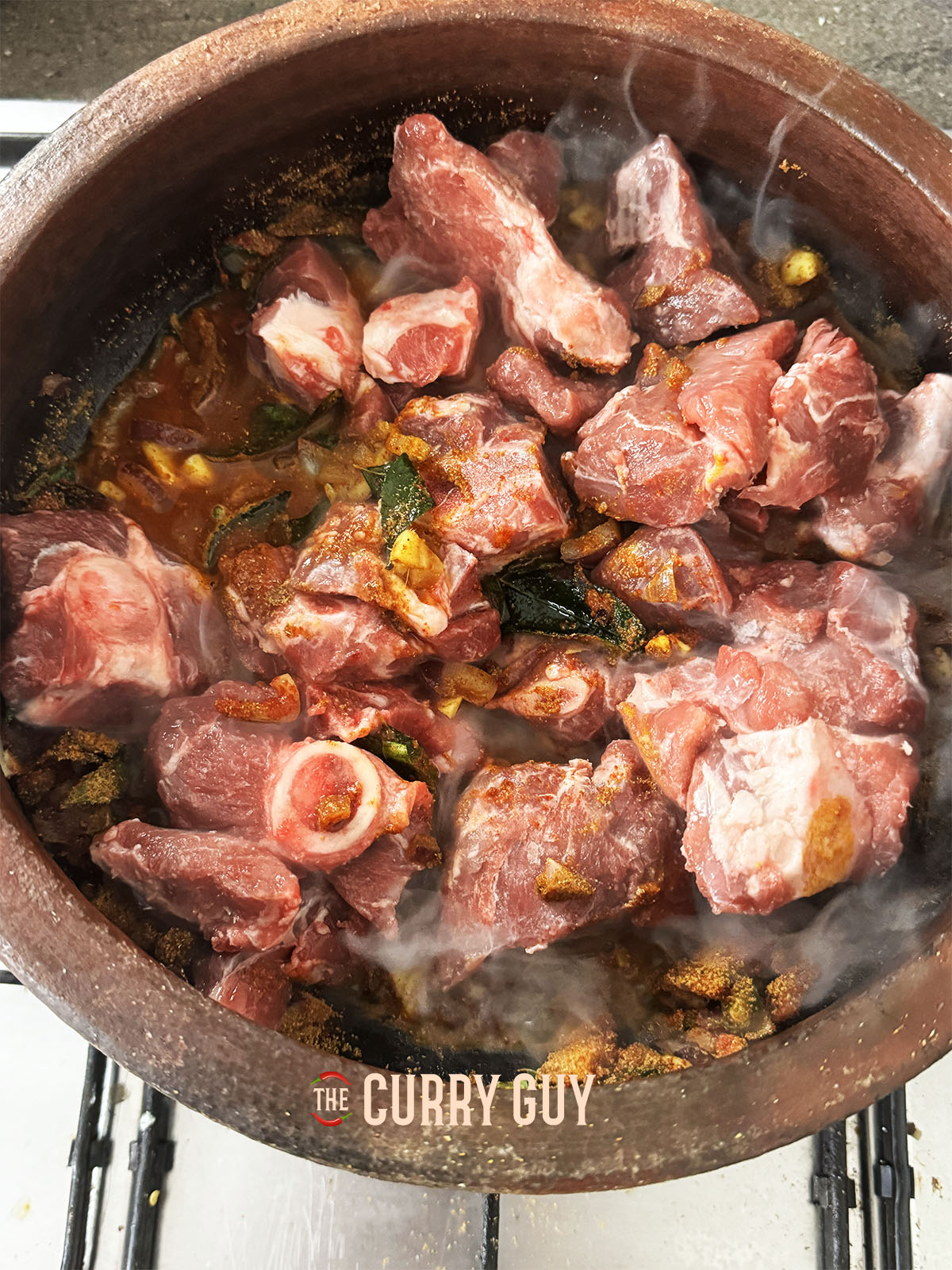 Adding the meat and a little water to the pot.