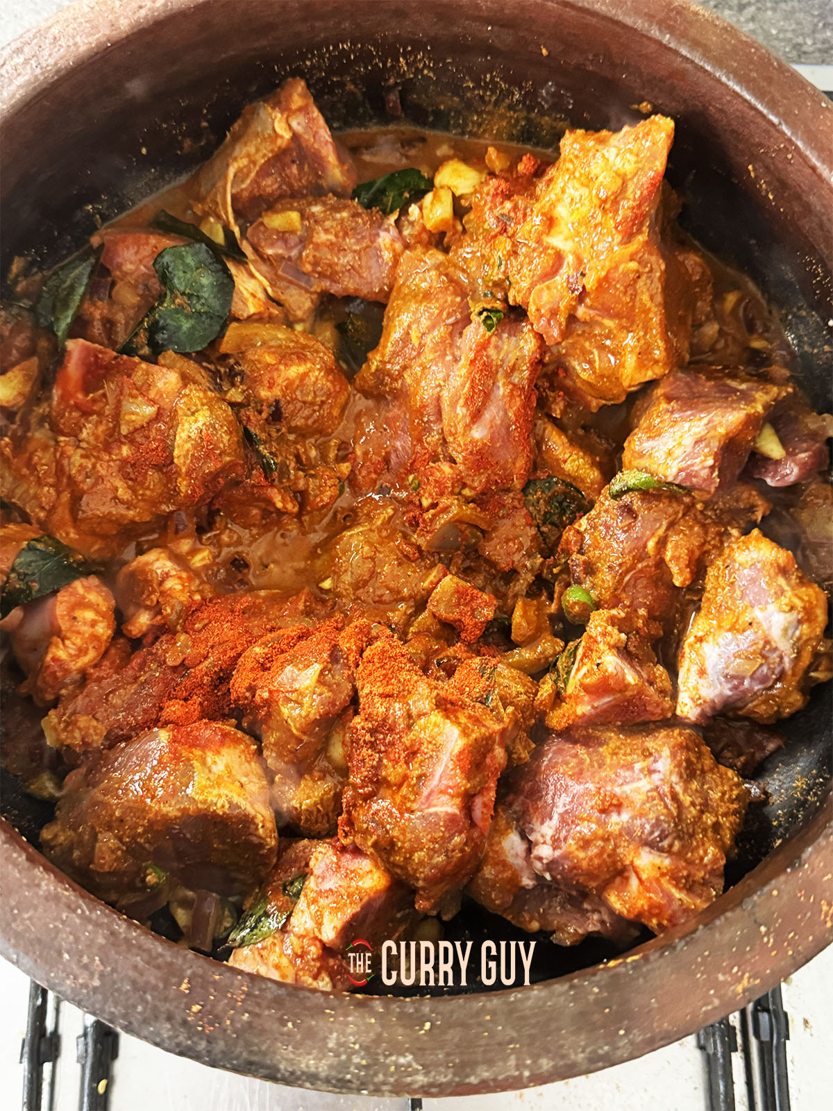 Stirring the meat into the base onion and spice mixture.