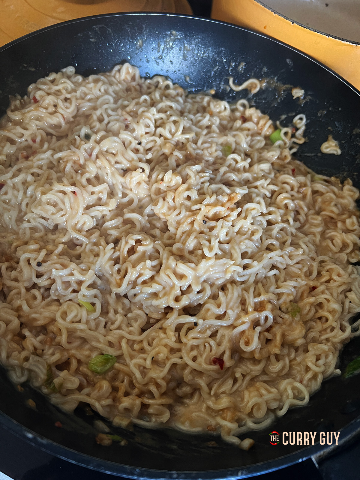 combining the sauce and the noodles for peanut butter noodles