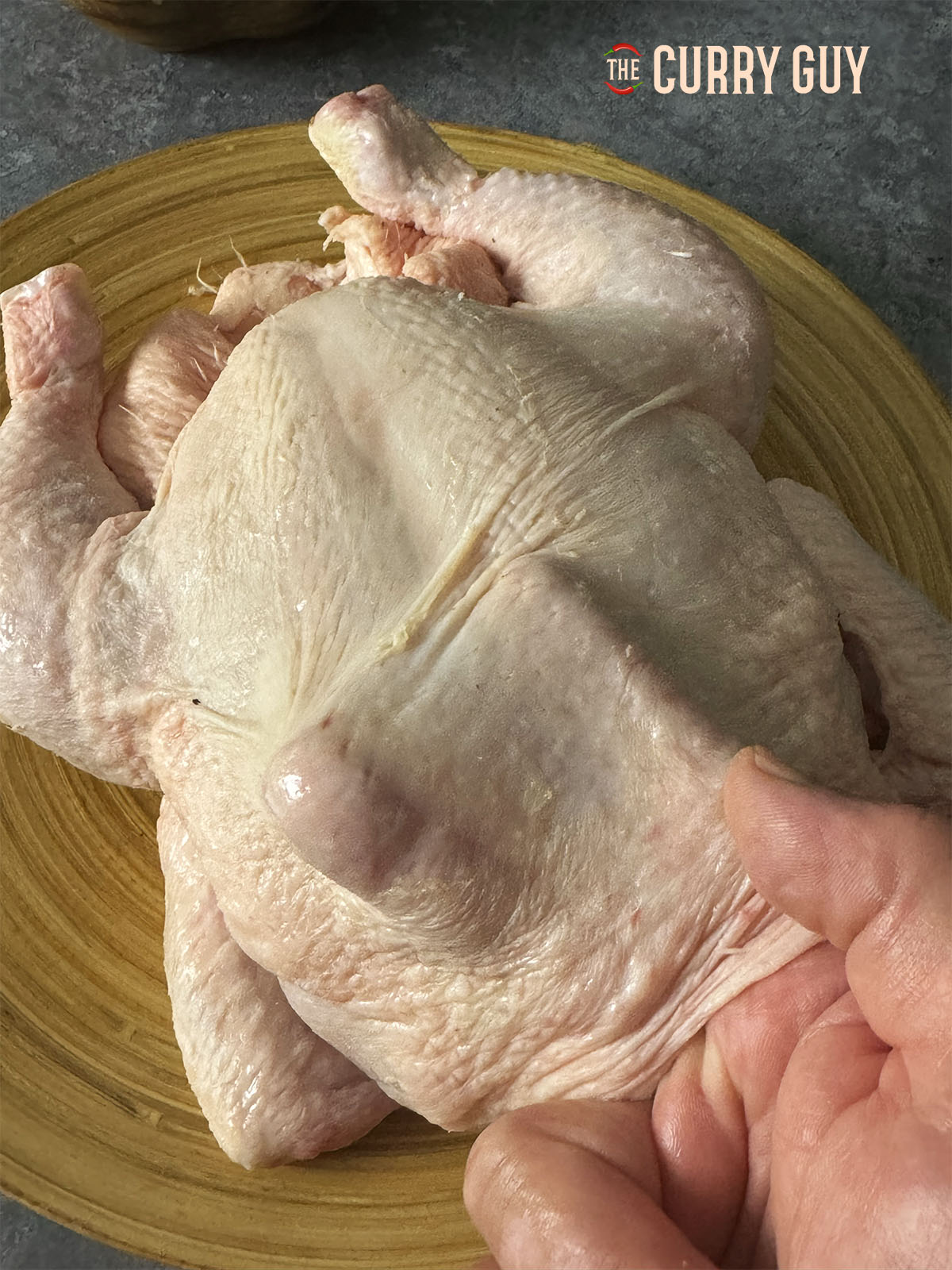 Making space underneath the skin of the chicken for the marinade.