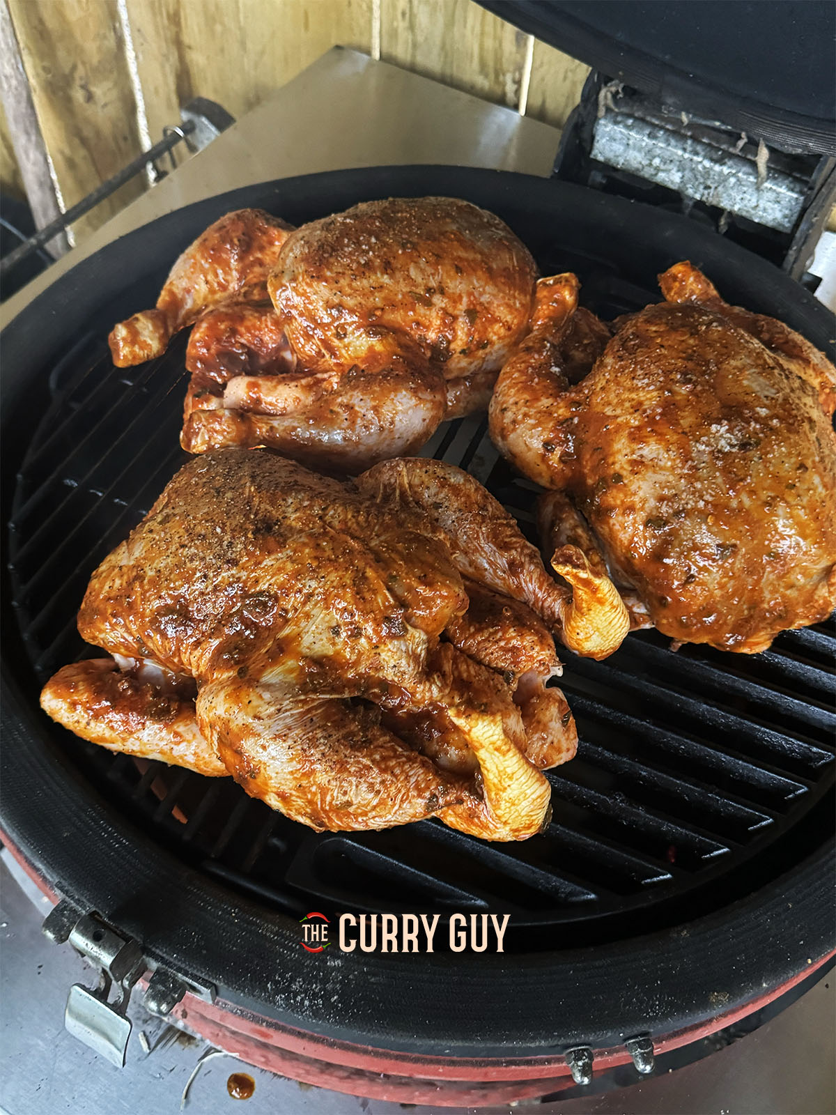The Peruvian chicken cooking over indirect heat on the barbecue.