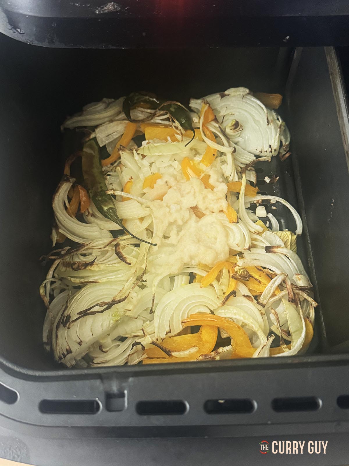 Air frying the sliced onions, bell pepper, chillies and garlic and ginger paste.