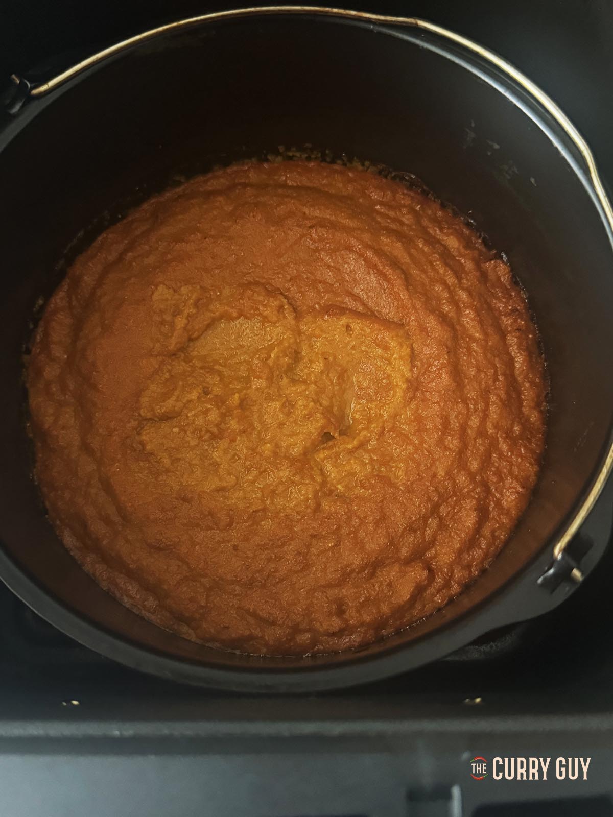 Heating the sauce in a small pan in the air fryer.