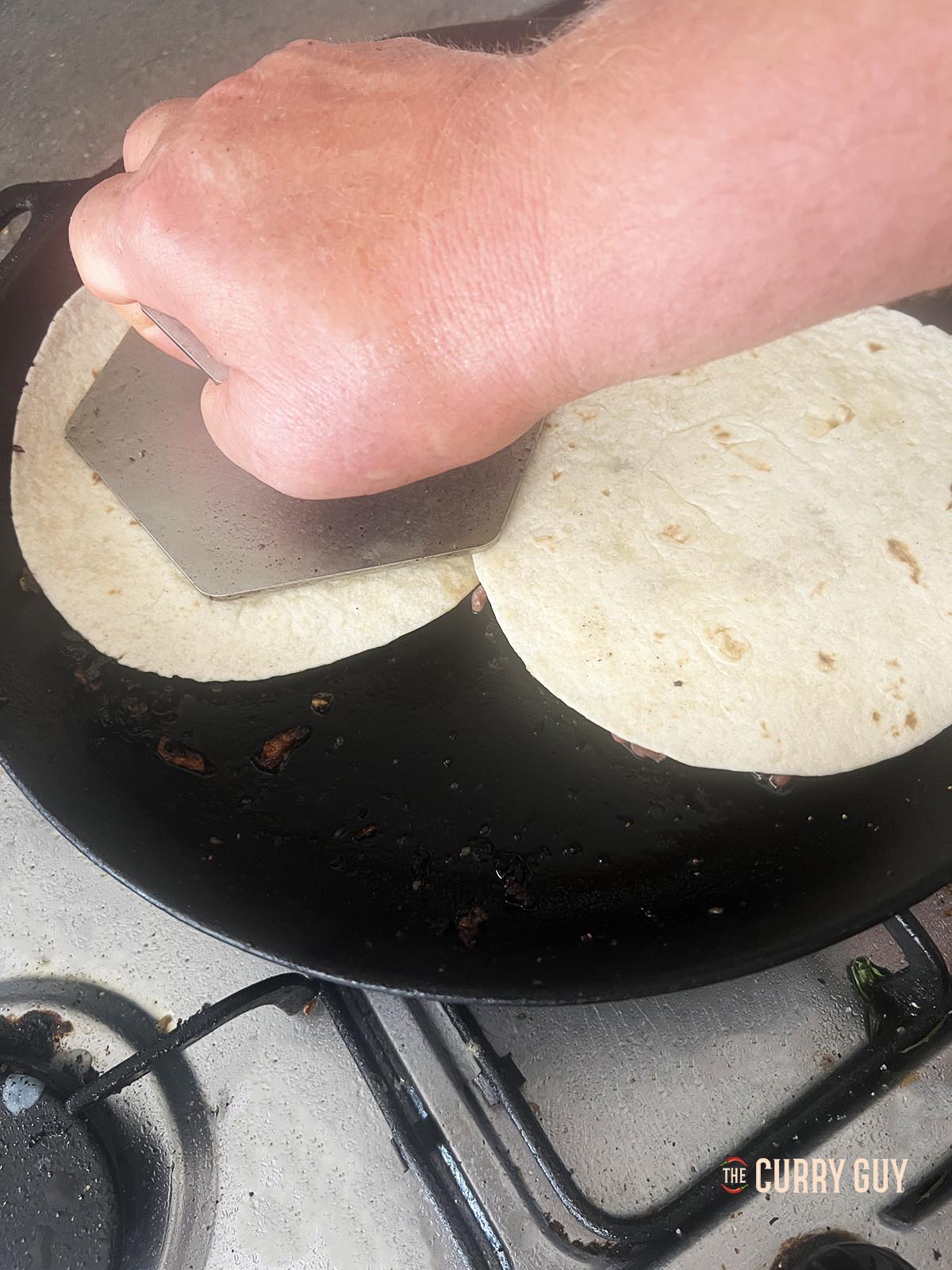 Frying the meat and tortillas with the meat side down and pressing them down with a burger press.