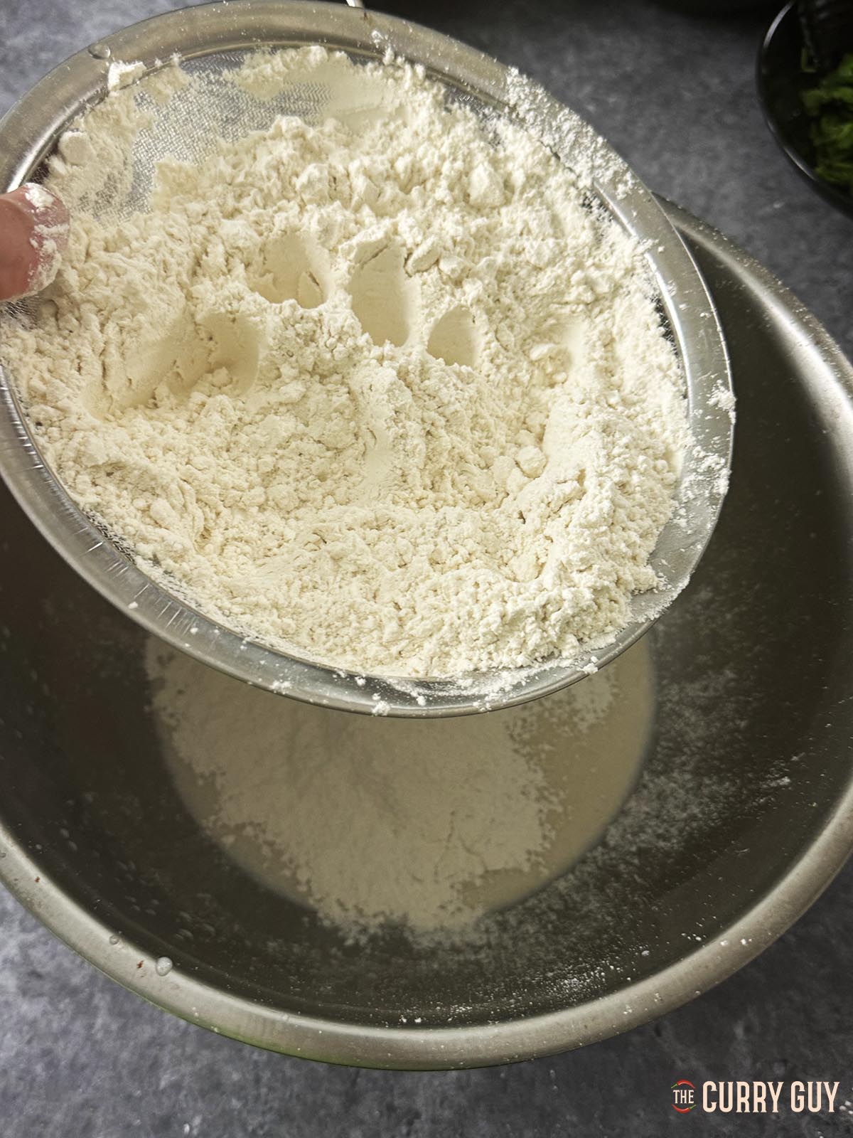 Sifting flour and salt into the yeast and milk mixture.