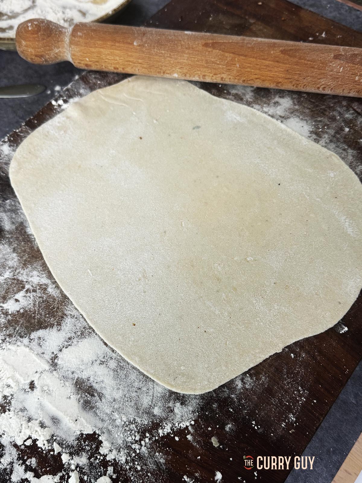 Rolling out one of the dough balls into a flat lavesh.