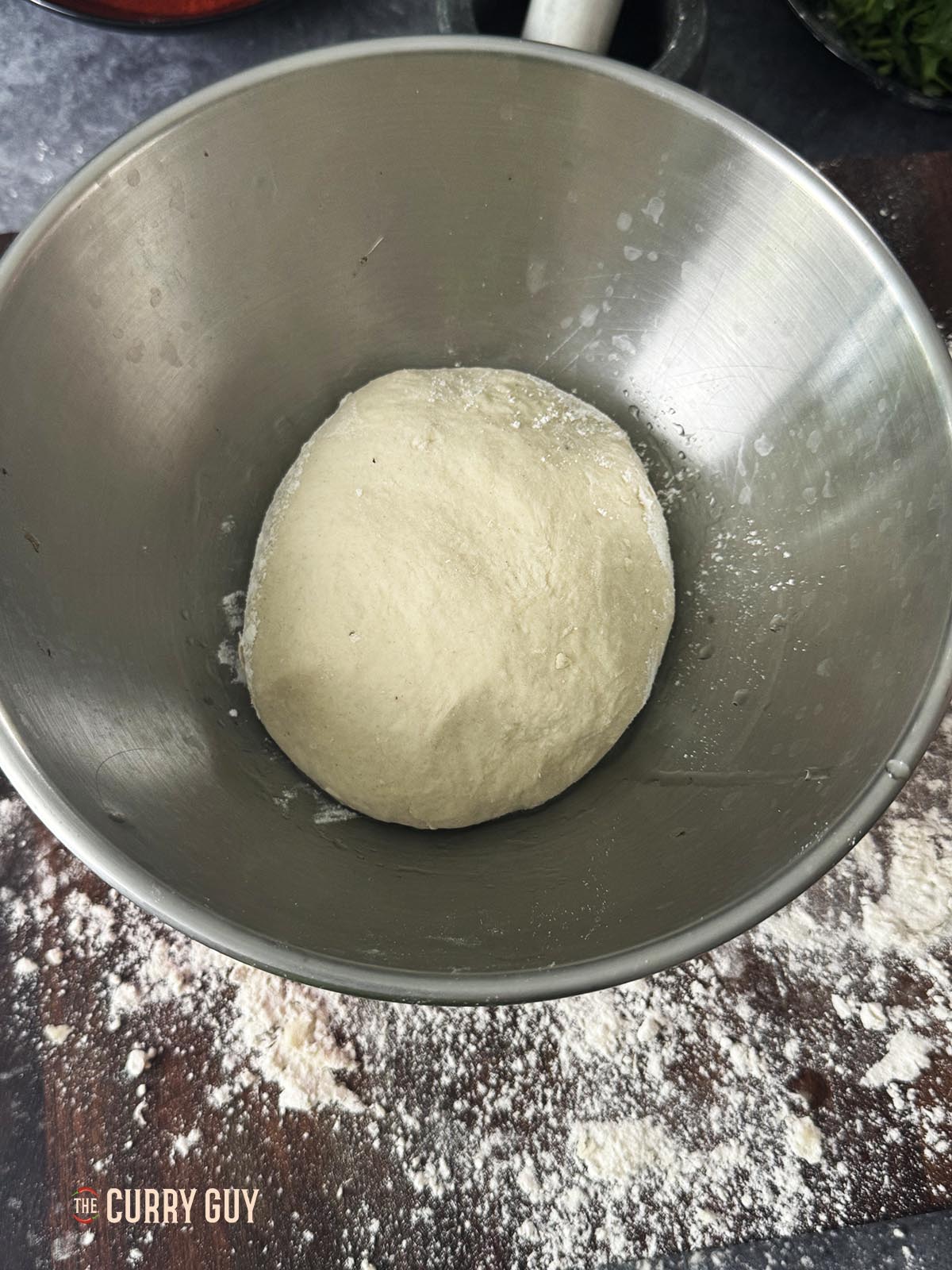 Placing the dough ball into a bowl to rise.