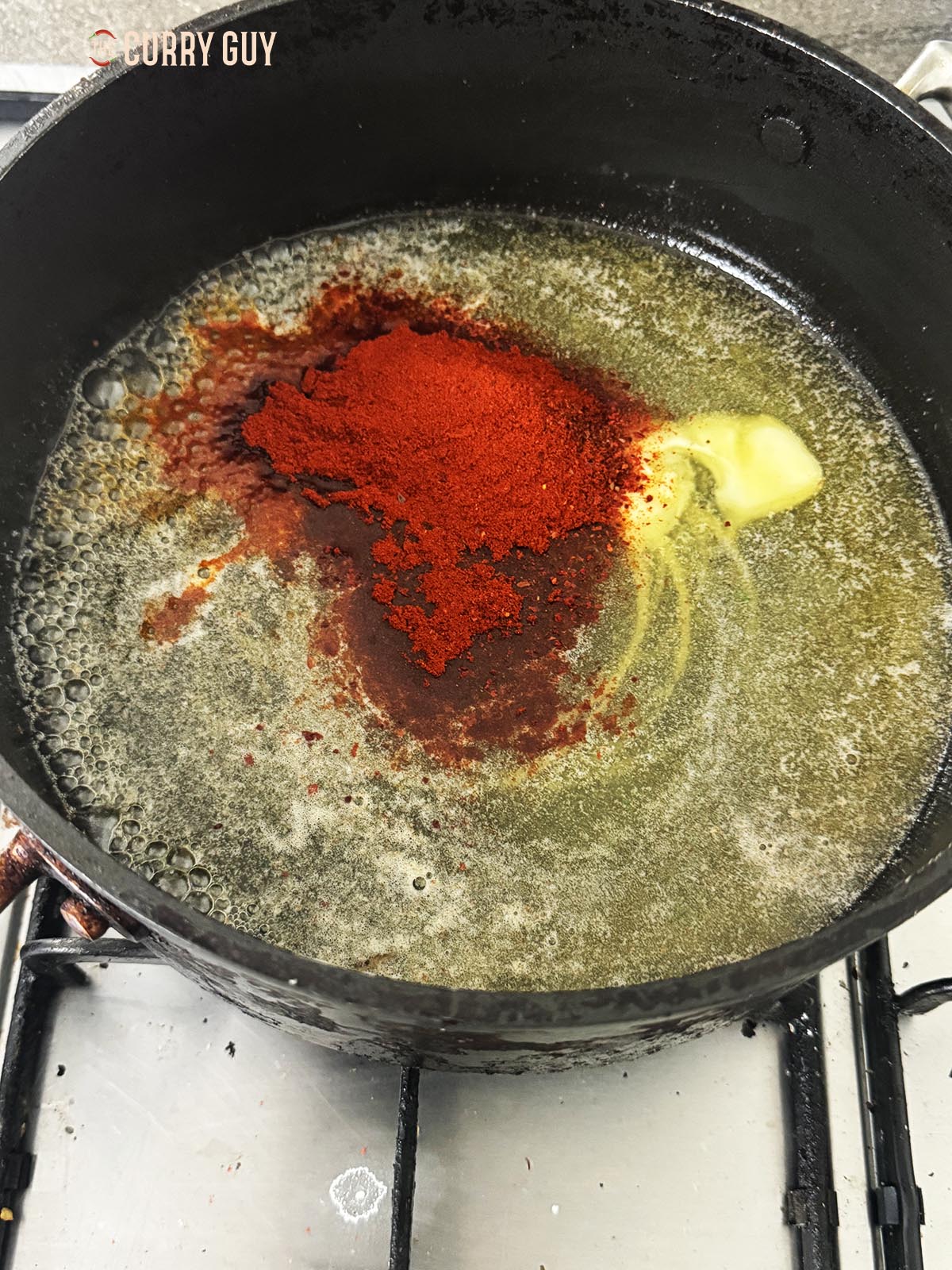 Heating the butter sauce with spices in a pan.