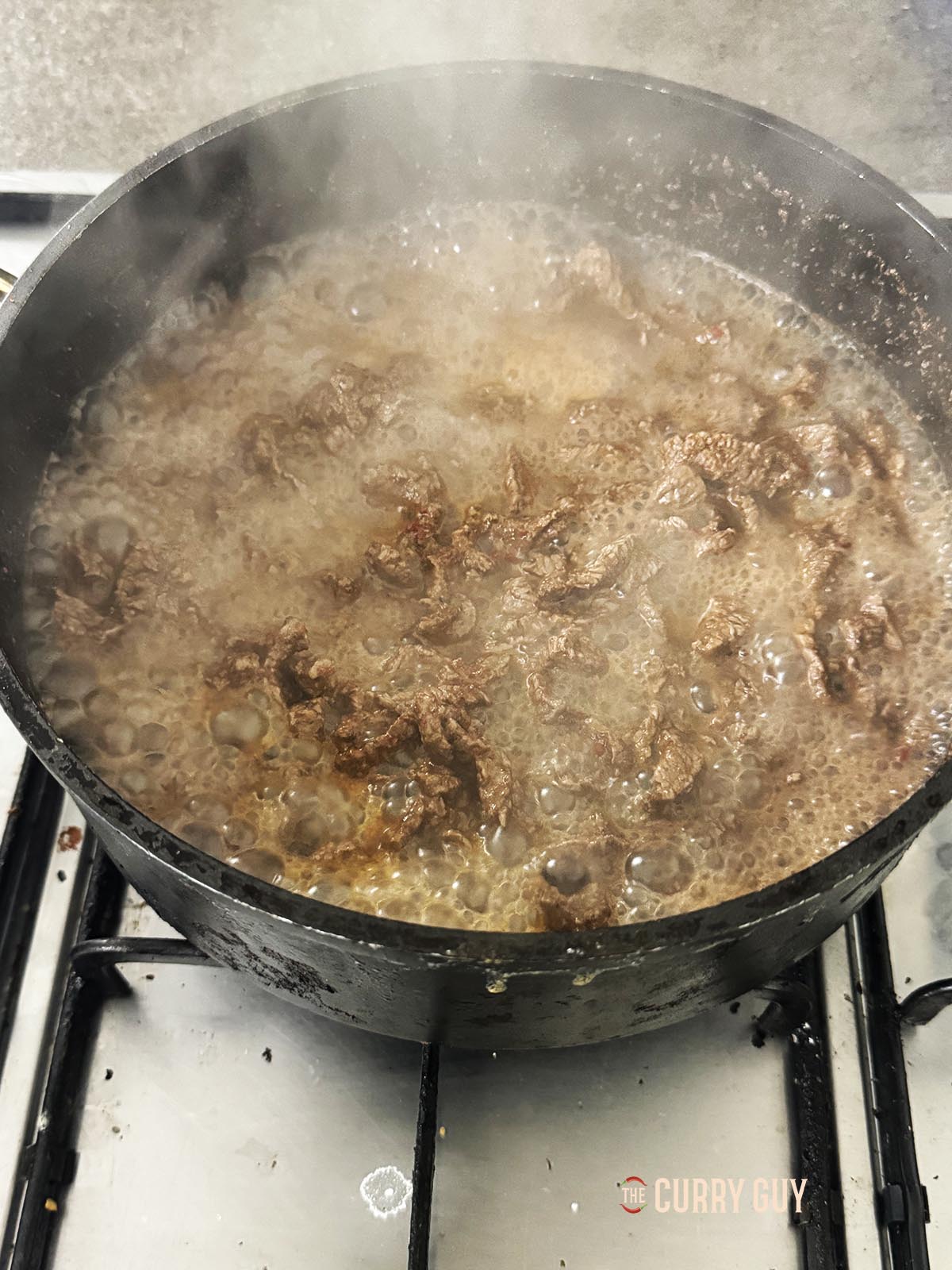 Simmering the meat in the pan.