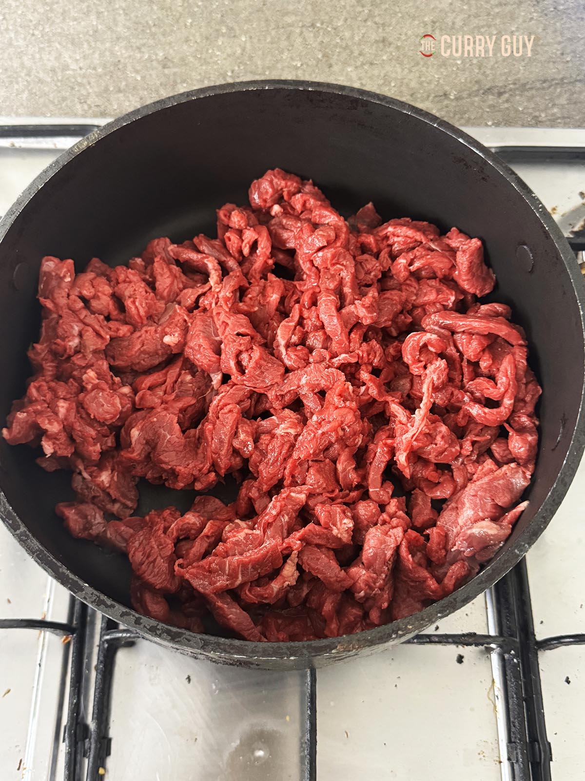 Frying the beef in a high sided pan.