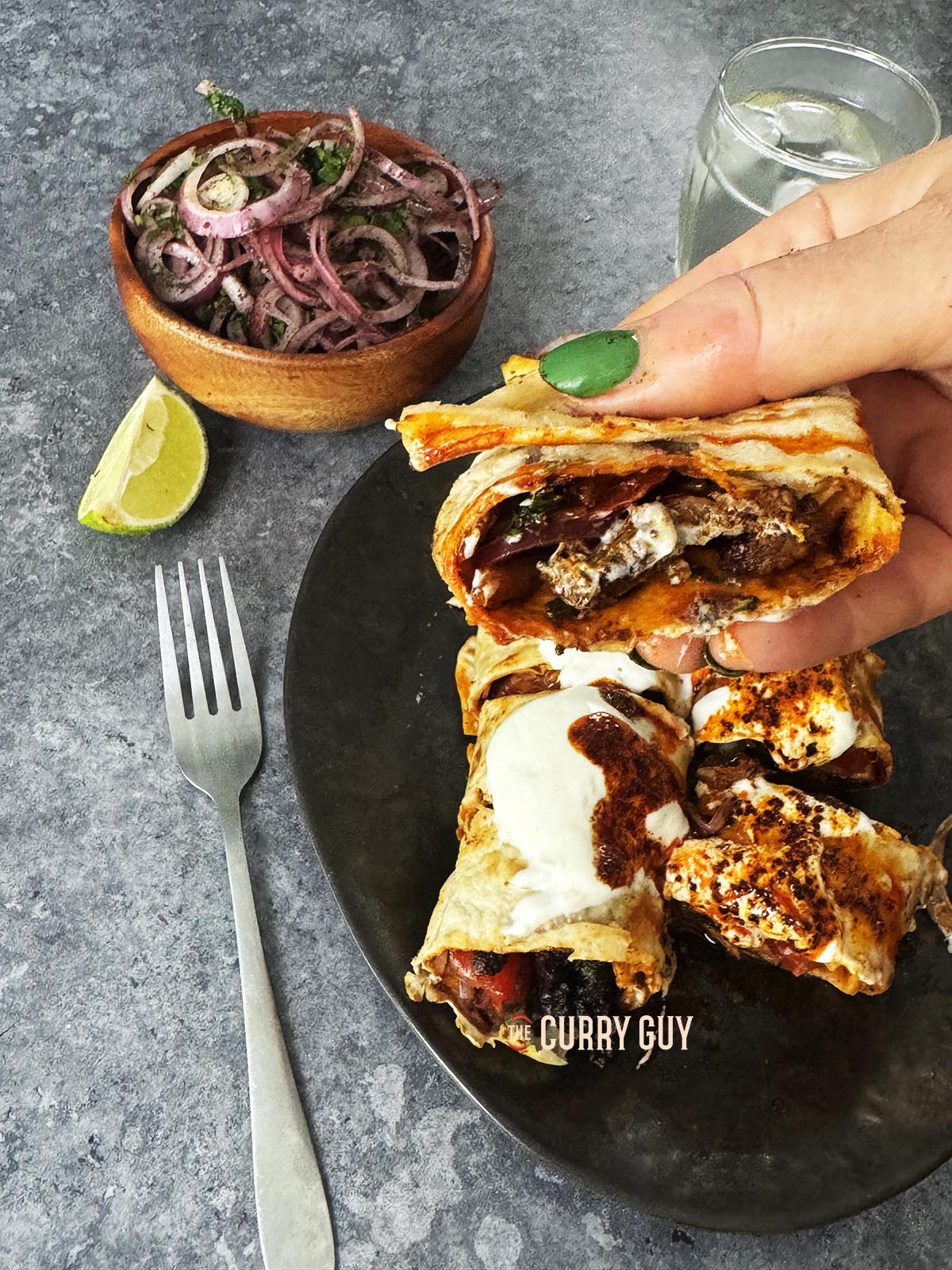 Hand holding a piece of tantuni.