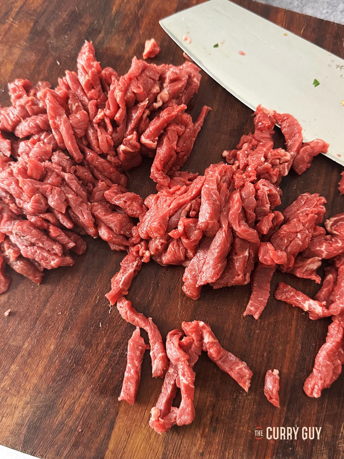 Slicing the beef into thin ribbons.