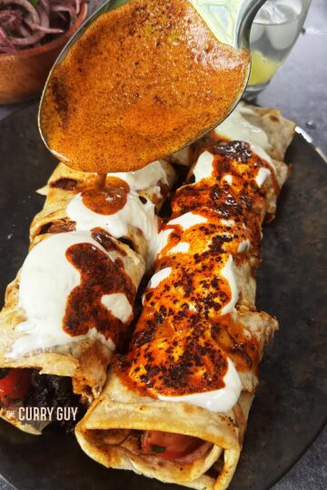 Drizzling the spiced oil over the yoghurt tantuni at the table.