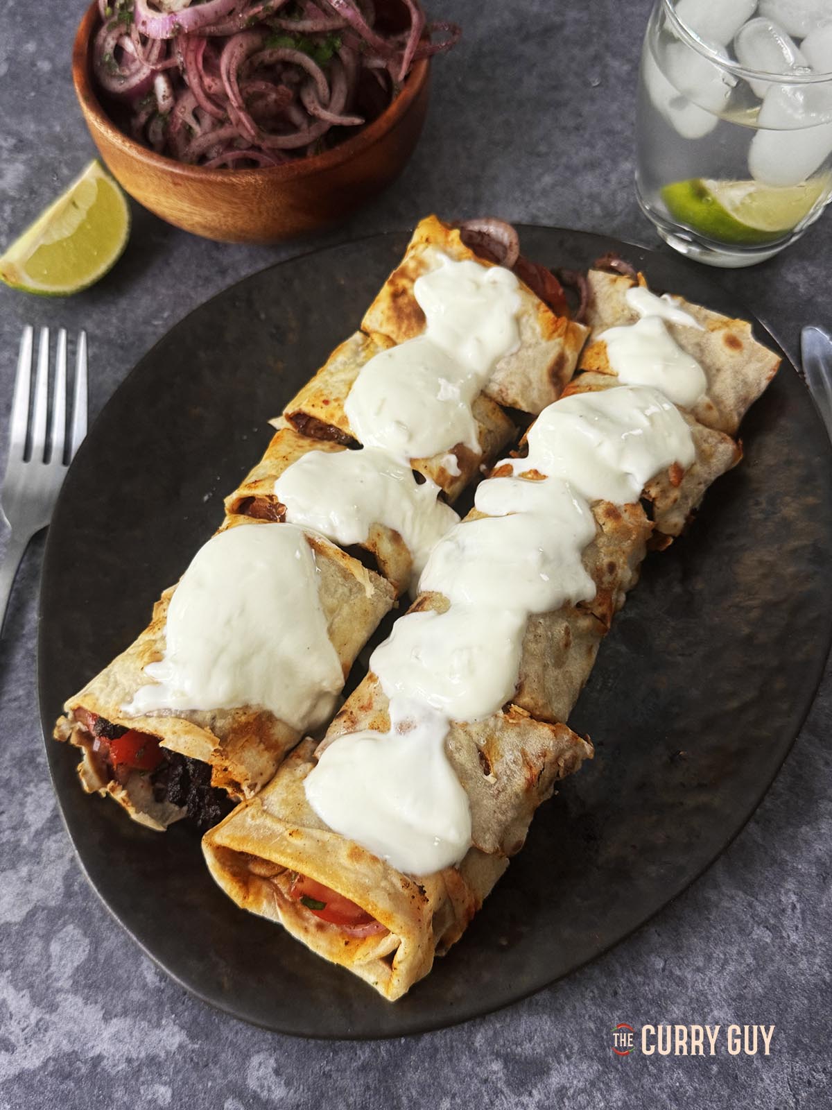 Covering the tantuni with yoghurt sauce.