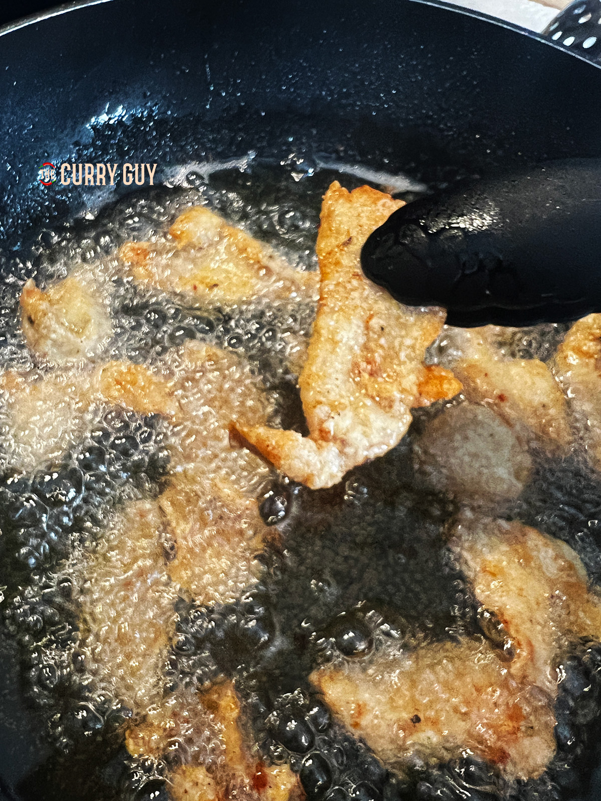 Chicken being fried in hot oil for Chicken Bao recipe.