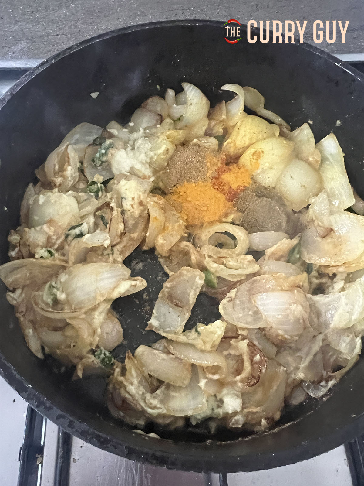 Adding the ground spices to the curry base. 