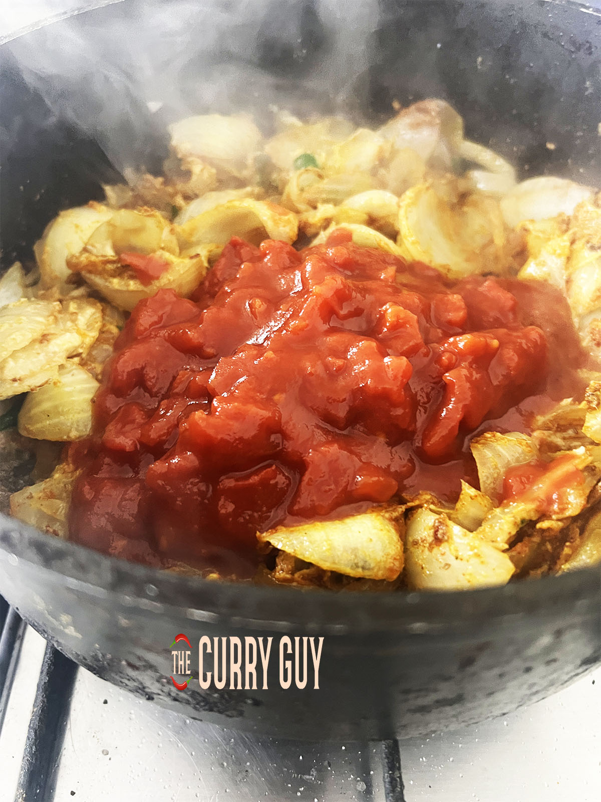 Adding the chopped tomatoes to the pan.