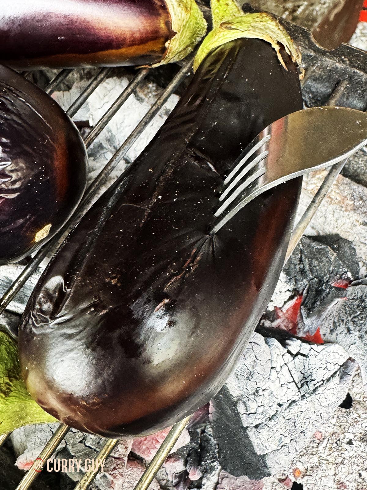 Pricking an aubergine with a fork. 