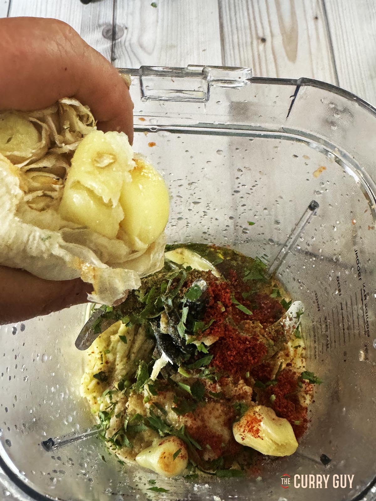 Adding roasted garlic to the blender.