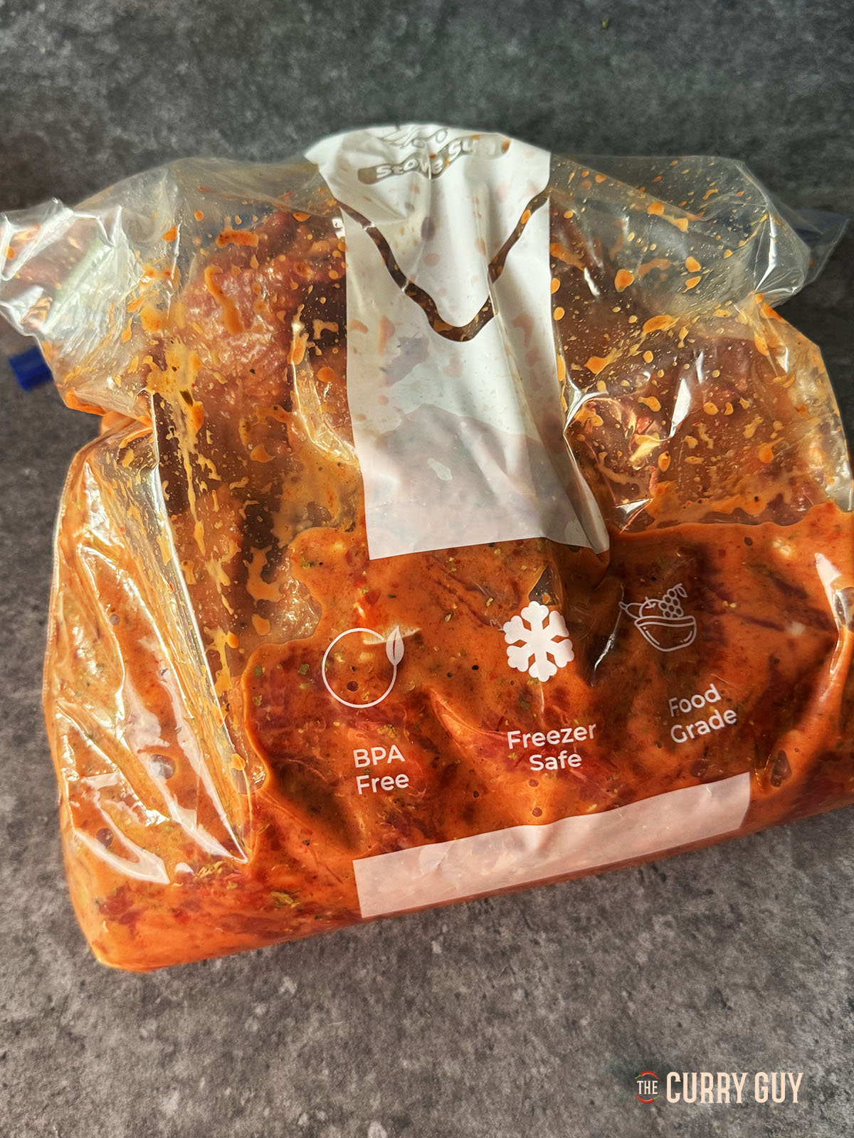 The beef marinating in the prepared marinade in a large freezer bag.