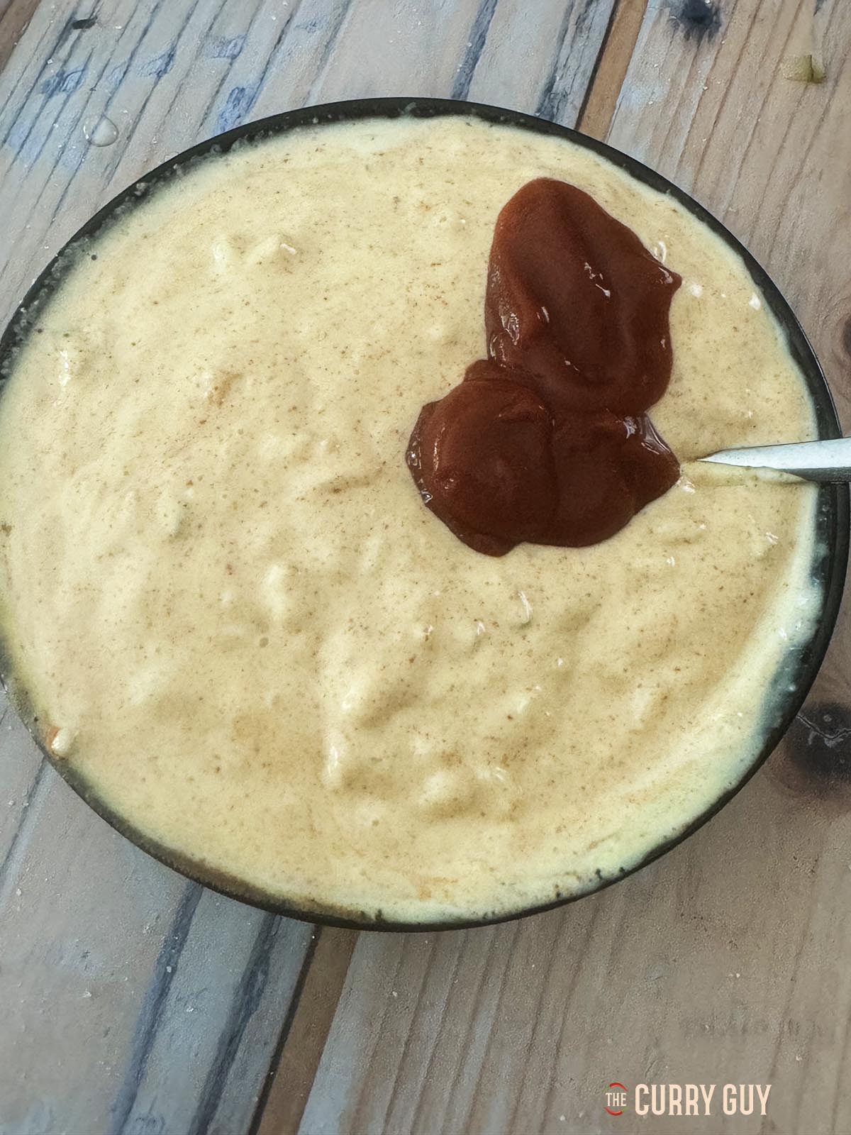 Adding ketchup to the sauce. 