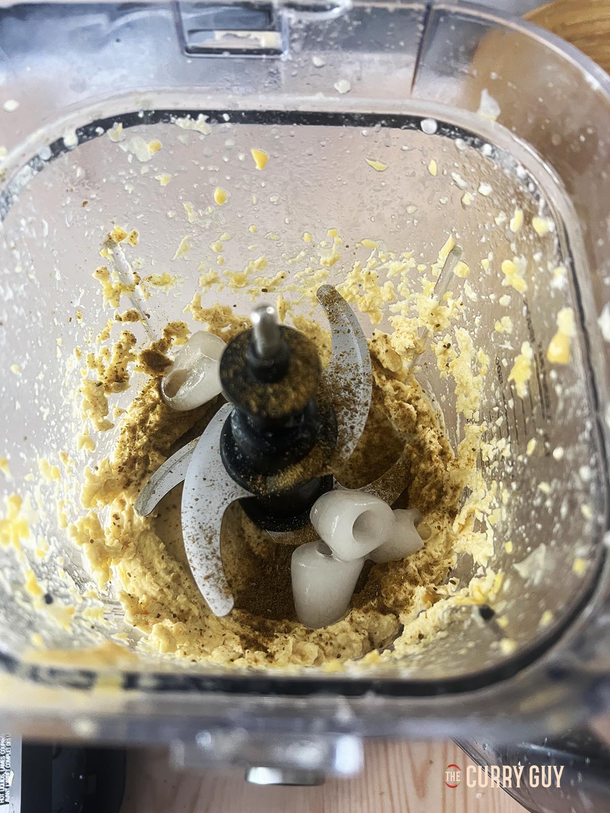 Adding the tahini and the remaining chickpeas to the blender along with two ice cubes.