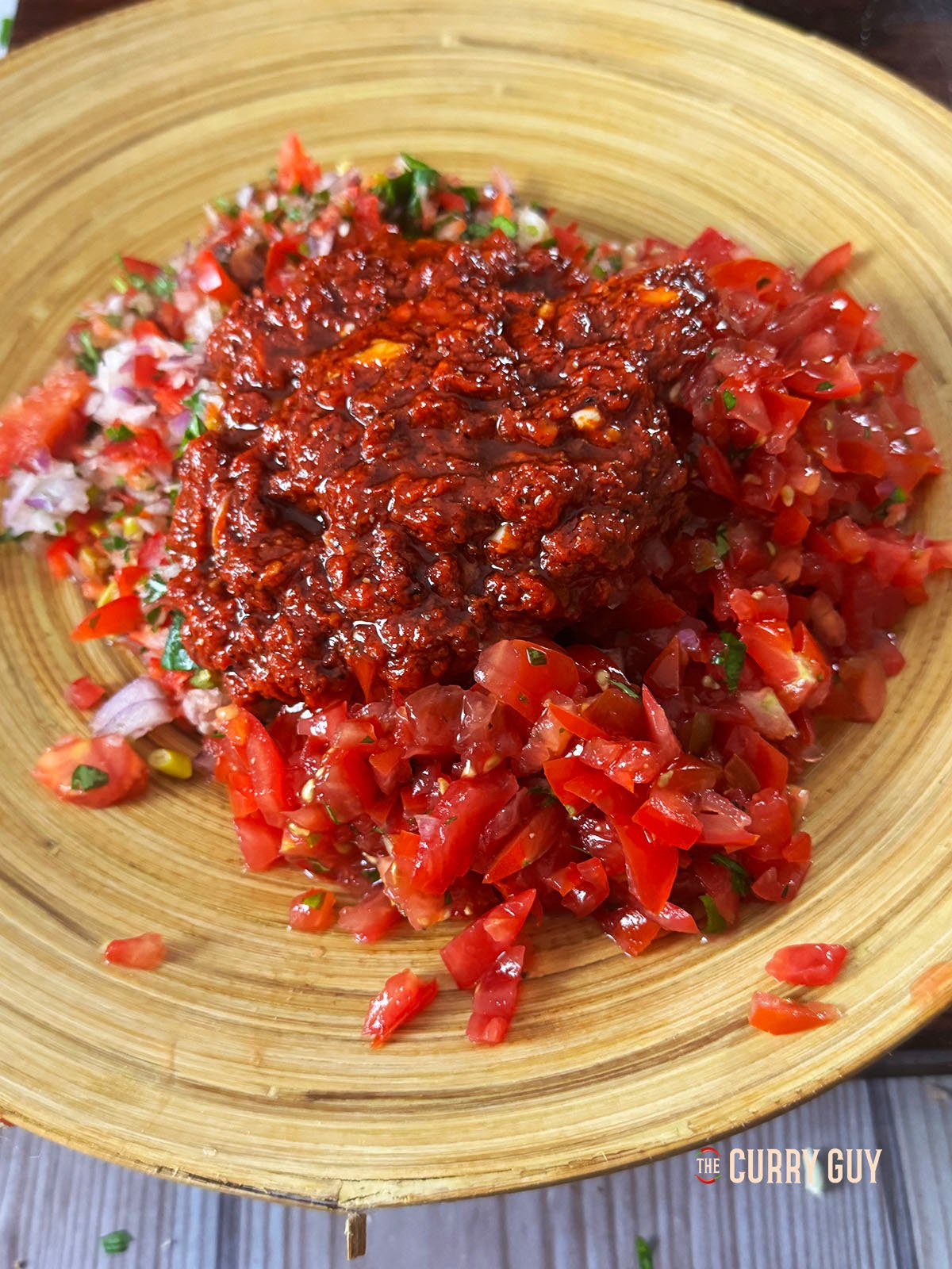 The dressing on top of the salad ingredients ready to toss together. 