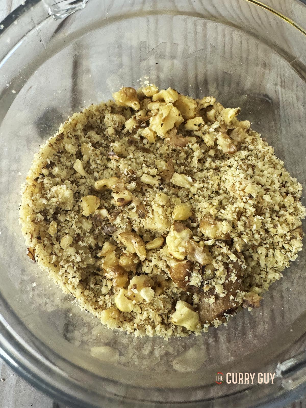 Placing the breadcrumbs and walnuts in a blender to pulse a few times.